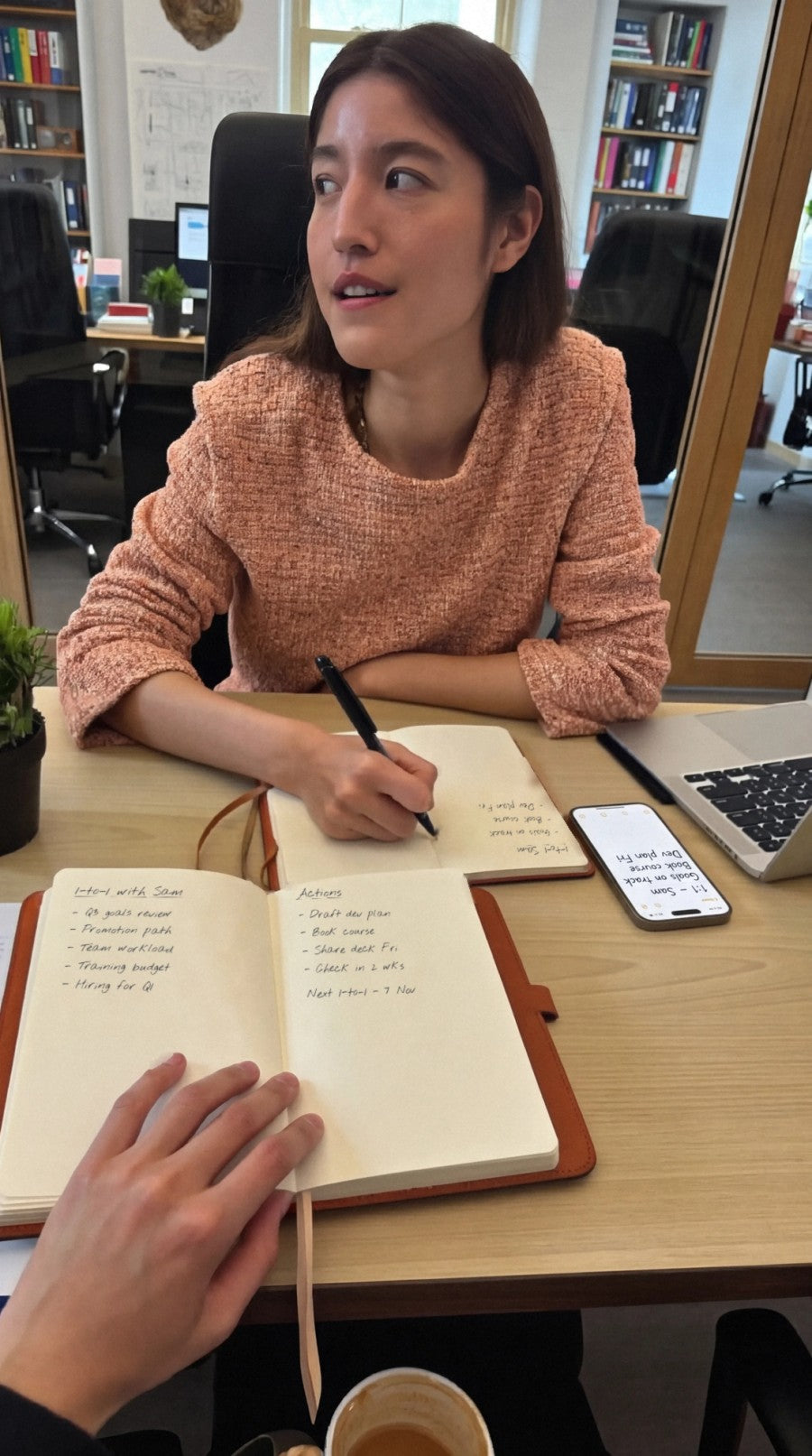 A one-to-one across a desk: both people take notes in NoteFlow while the notes sync to a phone